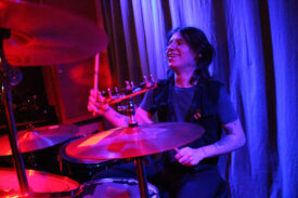 Der Schlagzeuger von Thee Kai Lehm lacht 